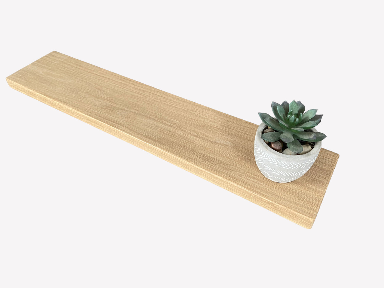 Slim oak floating shelf displaying a small plant to show the full length